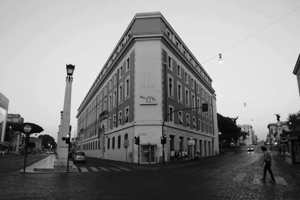 A black and white view of Rimini's iconic street corner, showcasing urban architecture and streetlife.