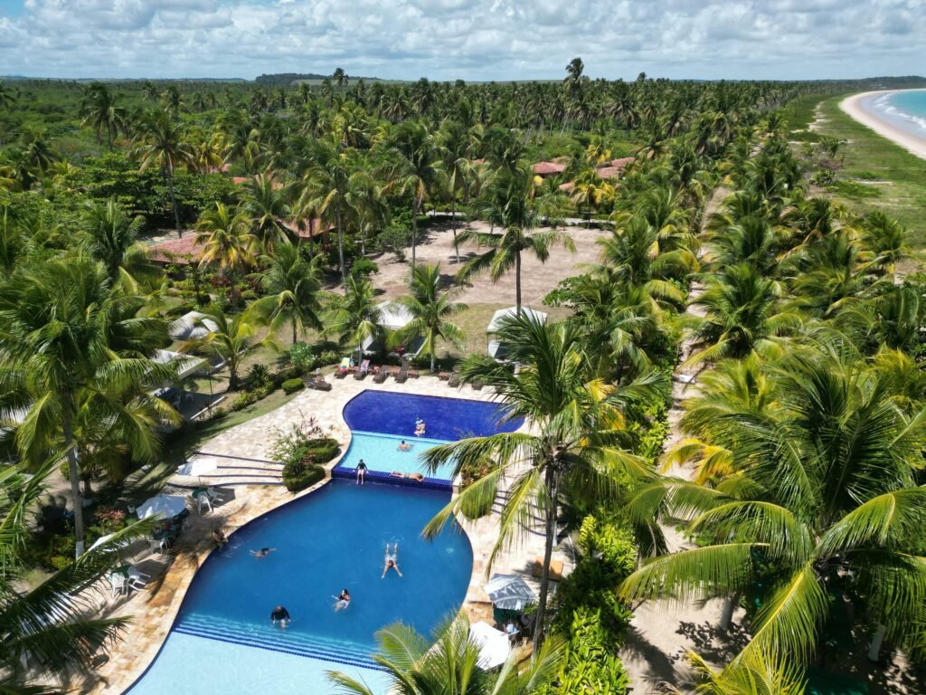 A stunning tropical resort featuring a lush landscape, pool, and beachfront. Perfect for a summer getaway.