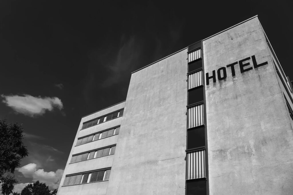 Black and white image of an urban hotel facade with clear skies.
